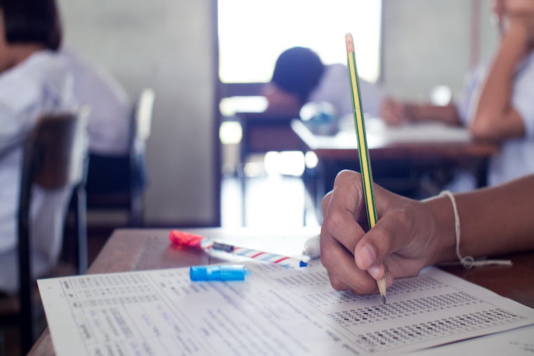 Hand of students writing and taking exam with stress in classroom.16:9 style